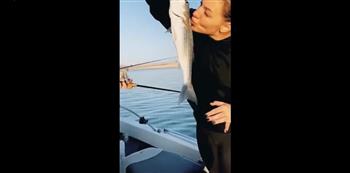 شاهد ماذا حدث لسيدة اصطادت سمكة وحاولت تقبيلها (فيديو)
