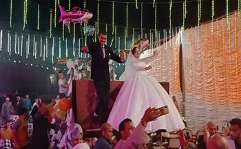 عروسان يحتفلان بزفافهما أعلى لودر في المحلة