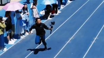 مصور يسبق العدائين أثناء تصوير سباق 100 متر (فيديو)