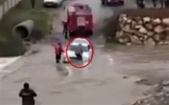كان يحاول دفع سيارته العالقة.. مياه السيول تجرف رجلًا بشكل مروع (فيديو)