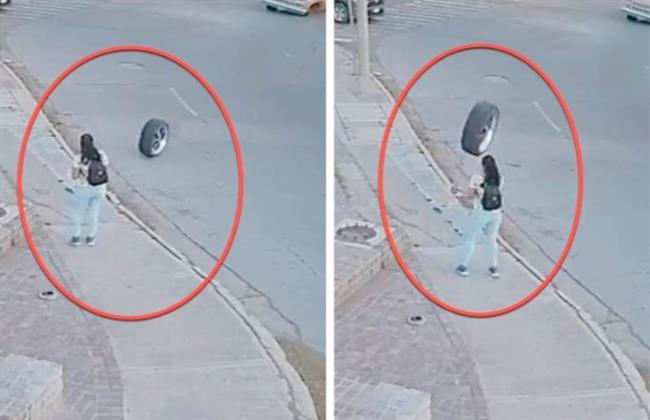 إطار سيارة طائش يندفع نحو رأس أمراة وأعجوبة تحدث في آخر لحظة (فيديو)