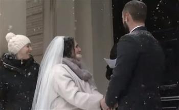 عروسان يقيمان حفل زفافهما وسط عاصفة ثلجية (فيديو)
