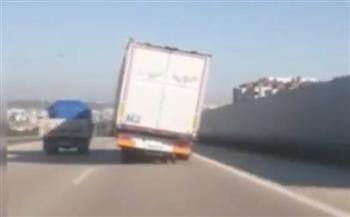 سائق متهور يقود شاحنة مائلة على طريق سريع (فيديو)