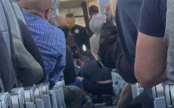 لحظات جنونية .. راكب أميركي يحاول فتح باب الطائرة في الجو (فيديو)