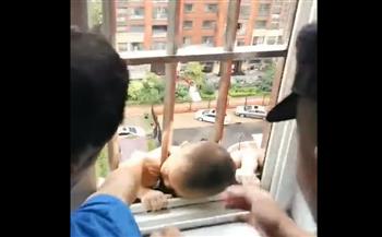 لقطات مروعة.. للحظة إنقاذ رضيع صيني تعلق من رأسه فى نافذة (فيديو)