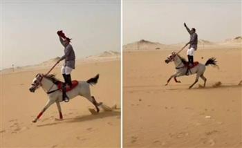 شاب يمتطي حصانًا يركض بسرعة هائلة وهو واقفًا على ظهره (فيديو)