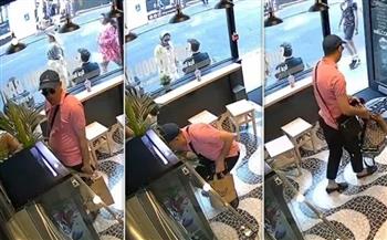 بطريقة ماكرة.. لص يسرق حقيبة امرأة داخل مقهى في لندن (فيديو)