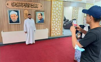 رواد معرض الإسكندرية للكتاب يلتقطون صورا تذكارية مع صورتي الرئيس السيسي وشيخ الأزهر