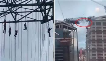 عمال يتعلّقون في الهواء على ارتفاع 500 قدم بعد انهيار سقالة بشكل مفاجئ (فيديو)