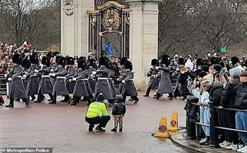 شرطي يخرج صبيًا أمام حشد قصر باكنجهام لمشاهدة تغيير الحرس