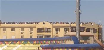 جمهور أسوان يشعل أجواء مباراة الأهلي من أعلى العمارات المجاورة للاستاد 