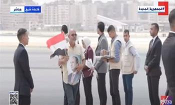 أحد المصريين القادمين من السودان يحمل صورة الرئيس السيسي وعلم مصر| فيديو