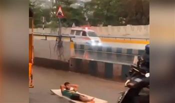 بالفيديو: هندي يركب الأمواج وسط الشارع باستعمال "مرتبة نوم"