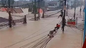 هربًا من الفيضان.. سكان تايلاند يتنقلون عبر الأسلاك الكهربائية (فيديو)