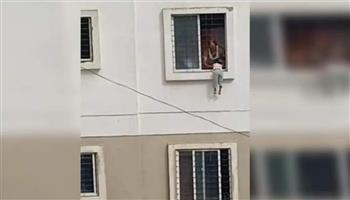 طفلة معلّقة في نافذة لمدة 15 دقيقة.. بطولة تنقذ حياتها (فيديو)