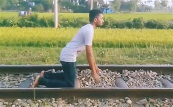 مغامر جنونية.. شاب يستلقي تحت عجلات قطار سريع لتصوير فيديو