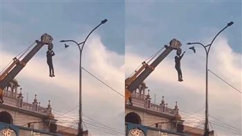 عملية إنقاذ غير عادية.. عامل يخاطر بحياته من أجل طائر عالق بين الأسلاك