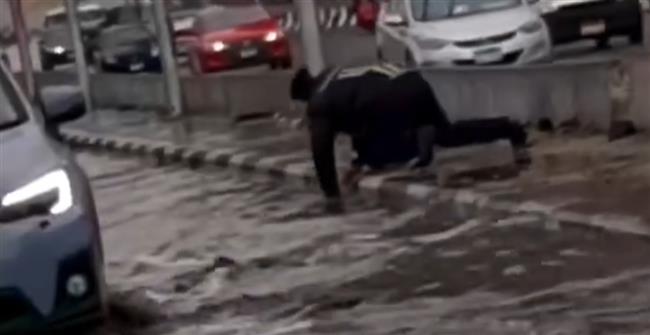 أمين شرطة يفتح مصافي الأمطار بنفسه لتيسير حركة المرور بالدائري المعادي